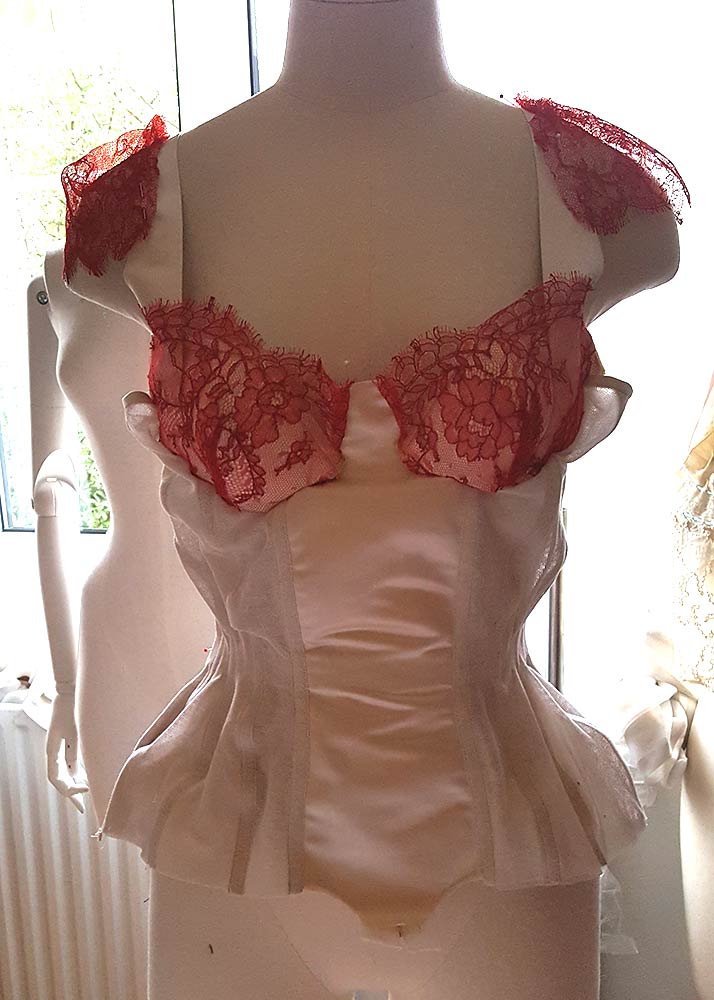 Cups pinned into a partially constructed corset base, lace draped for sleeve detail placement Photo by Karolina Laskowska